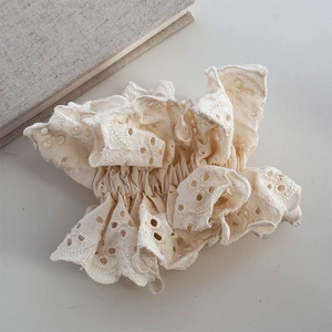 Close-up of cream lace scrunchie with intricate Broderie Anglaise hollow embroidery details