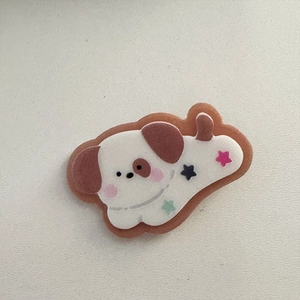 Dettaglio del fermaglio per capelli a forma di cucciolo ricamato con stelle colorate e guance rosa