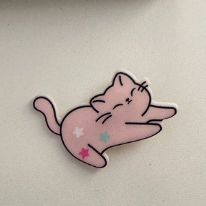 Dettaglio della molletta per capelli a gatto rosa con stelle colorate e finitura opaca