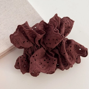 Macro shot of bordeaux red eyelet lace embroidery on a large pleated hair scrunchie