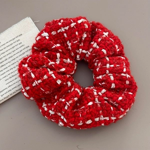 Detail shot of red and white tweed scrunchie with rich woven texture for Christmas style