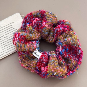 Macro shot of colorful chunky knit scrunchie with soft wool texture and fabric label