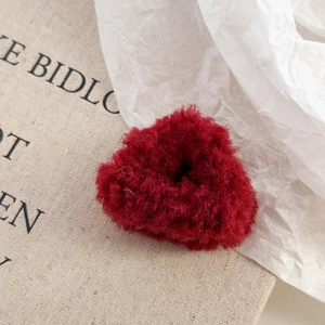 Détail d'un chouchou en peluche rouge en forme de cœur avec une texture douce et soyeuse