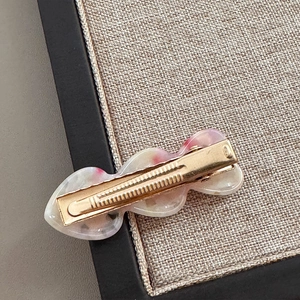 Detailansicht der wellenförmigen Haarspange mit goldenem Entenschnabel-Metallclip