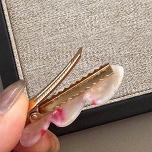Detailaufnahme der Marmortextur Acetat Haarklammer mit goldenem Metallgriff