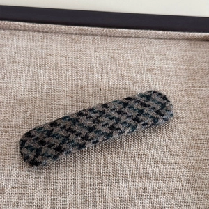 Détail de la texture en tissu pied-de-poule sur la pince à cheveux rétro marron et noir