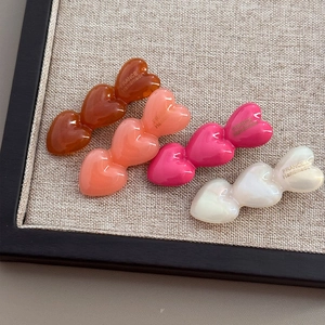 Set aus vier handgefertigten Acetat-Haarspangen in Herzform in Bernstein und Pink