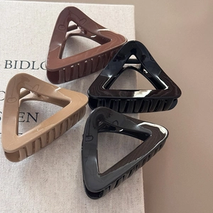 Set of four geometric hollow triangle hair claws in classic black, brown, and nude tones