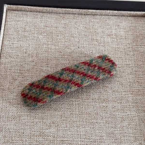 Détail de la texture en tissu à carreaux vintage rouge et vert sur la barrette