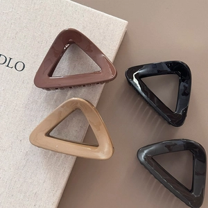 Detailed set of four hollow triangular hair claws in brown, beige, black, and dark grey colors
