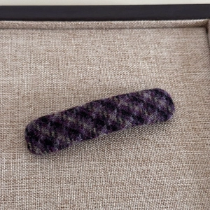 Détail d'une pince à cheveux vintage à carreaux violet et olive sur plateau en lin