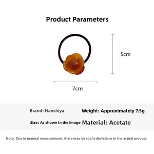 Detail showing amber acetate flower hair tie with dimensions 7cm and 5cm on white background