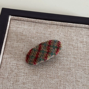 Vue détaillée d'une barrette ovale en tissu à carreaux avec texture laineuse pour l'automne