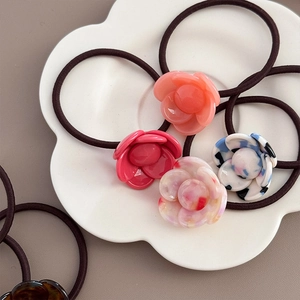 Macro detail of multi-colored floral resin hair ties in a decorative petal tray