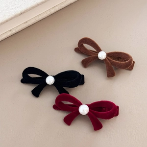 Détail des barrettes nœuds en velours noir marron et rouge avec perle centrale