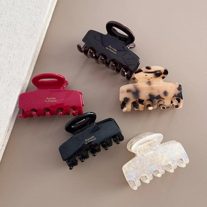 Flat lay of five retro square hair claws in assorted colors with gold France lettering