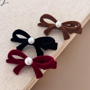 Trois barrettes à nœuds en velours marron, noir et rouge avec une perle centrale élégante
