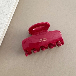 Detail of burgundy glossy hair claw clip featuring golden Barrette La France text