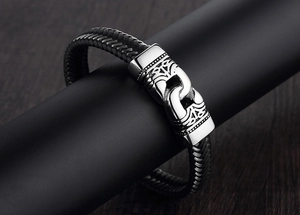 Primer plano de pulsera trenzada negra para hombre con cierre de acero grabado vintage