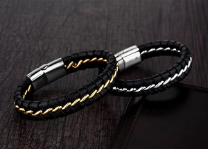 Détail de bracelets en cuir tressé noir avec inserts de chaîne en argent et or