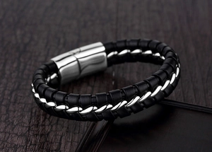 Détail d'un bracelet en cuir tressé double rangée avec chaîne torsadée et fermoir magnétique