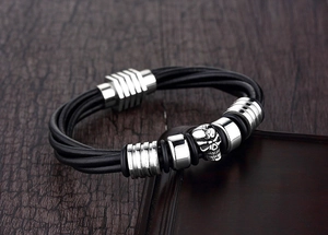 Close-up of punk style multilayer leather bracelet with a silver skull and metal beads