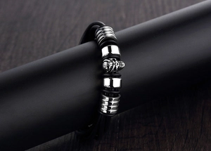 Macro view of multilayer black leather bracelet with polished silver skull and beads