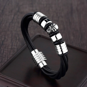 Men's punk leather bracelet with stainless steel skull and magnetic clasp on wood