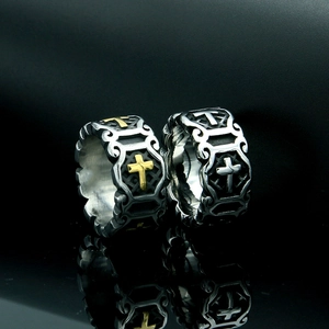 Close-up of gothic stainless steel cross rings with vintage relief and metal textures