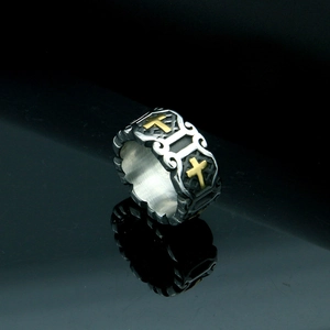 Macro detail of gothic signet ring with golden cross and floral scroll engraving