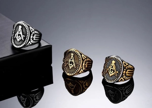 Close-up of vintage Freemasonry rings in silver, bronze and gold tones with G symbol