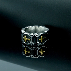 Macro shot of vintage silver ring with gold cross and embossed floral scrollwork