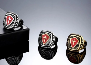 Macro shot of vintage cross shield rings in gold and silver finish with red enamel inlay