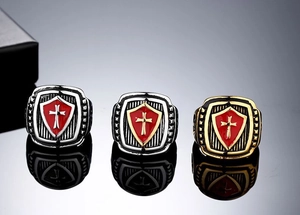 Macro shot of three vintage shield cross rings showing red enamel and metallic textures