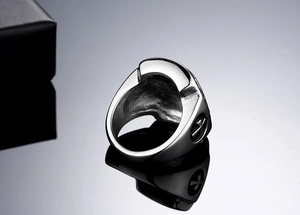 Detail view of silver cross shield ring featuring hollow interior and embossed side patterns