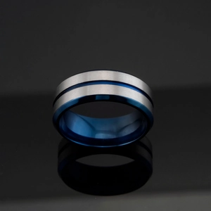Detail of matte brushed titanium steel ring with blue groove and polished interior