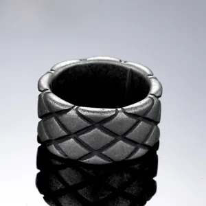 Macro shot of silver titanium steel ring with vintage quilted rhombic pattern textures
