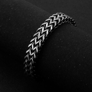 Dettaglio macro del bracciale da uomo in acciaio al titanio intrecciato grigio