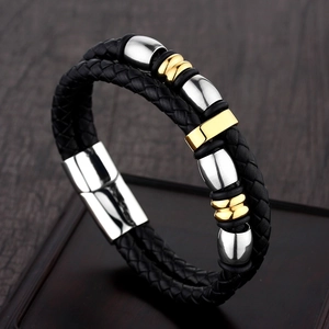 Close-up of dual-layer black braided leather bracelet with gold and silver metal accents