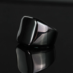 Macro shot of polished black square signet ring with high gloss mirror reflection