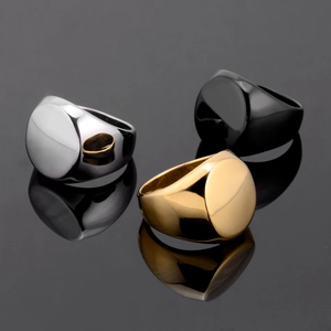 Chevalières en acier inoxydable poli en argent, or et noir sur surface sombre