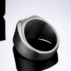 Macro close-up showing brushed titanium steel texture and thick band of the men's ring