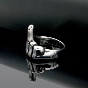 Close-up of polished stainless steel middle finger gesture ring on black surface