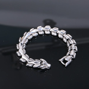 Detailed macro view of silver dragon scale links and carved dragon head clasp closure