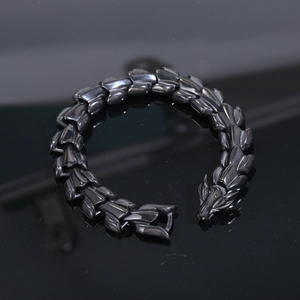 Detail of black titanium steel dragon scale bracelet featuring a bold dragon head clasp