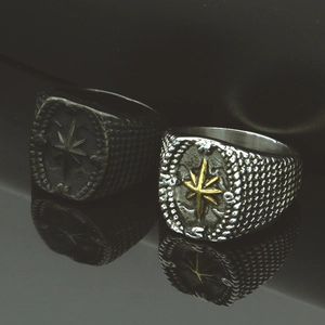 Macro detail of men's vintage compass rings in matte black and gold-silver steel finish