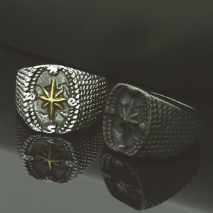 Macro detail of vintage nautical compass rings with engraved stars and oxidized finish