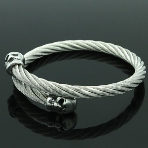 Primer plano de pulsera trenzada de acero inoxidable con extremos detallados de calavera