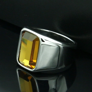 Macro-detail van herenring van titaniumstaal met smaragdgeslepen amberkleurige edelsteen