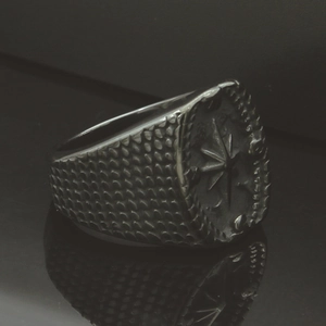 Macro shot of vintage steel compass signet ring with engraved fish scale pattern